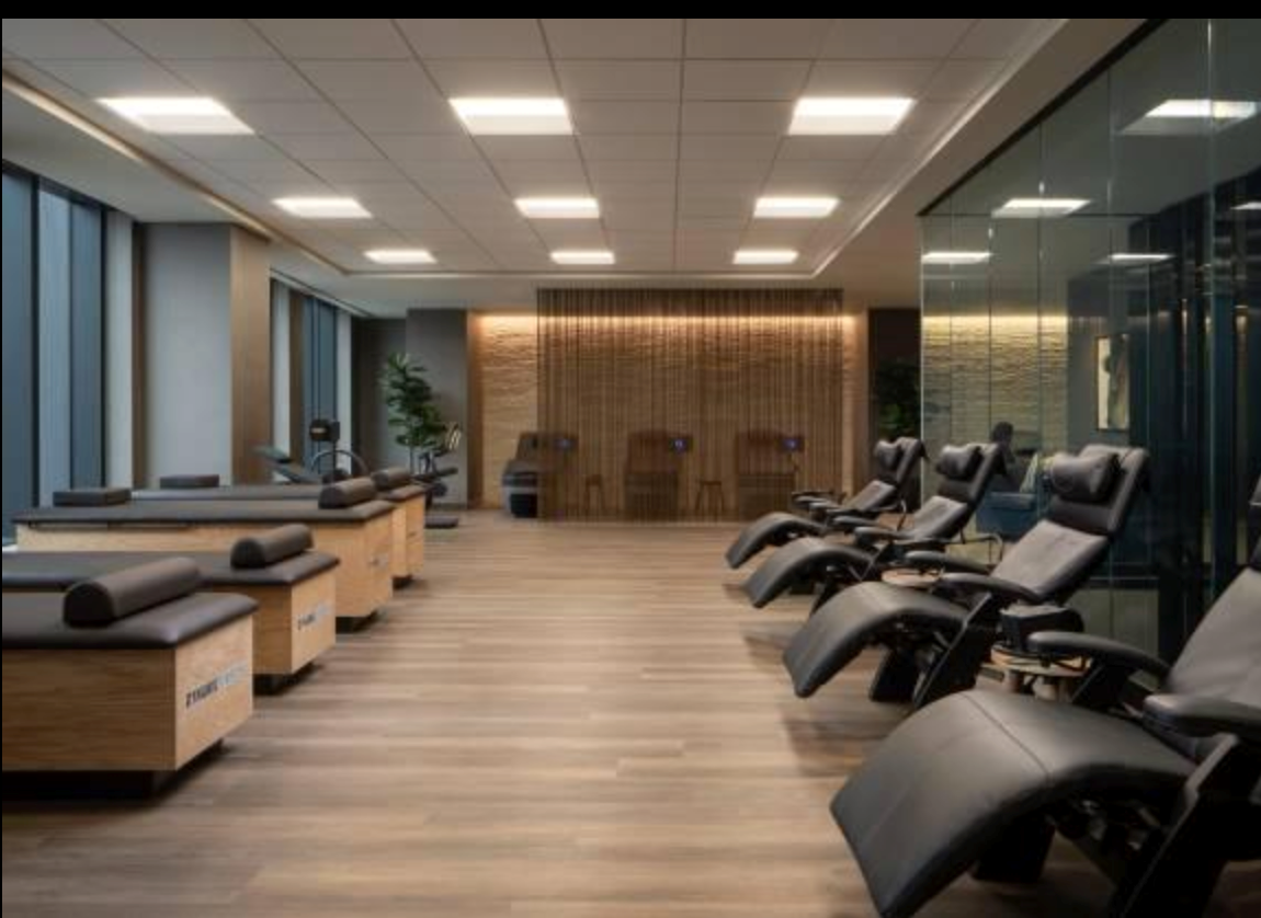 Modern muscle recovery system lounge featuring compression therapy equipment and relaxation chairs.