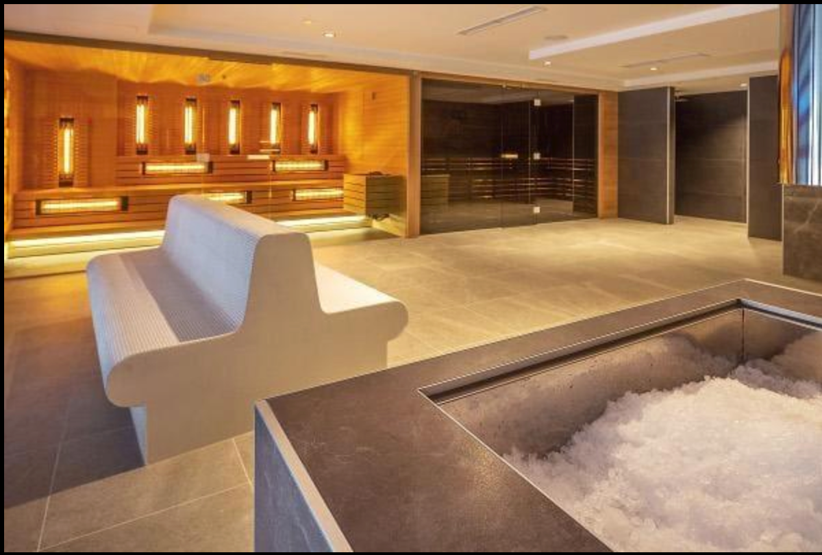Modern wellness recovery area with contrast therapy equipment and ergonomic relaxation chairs.