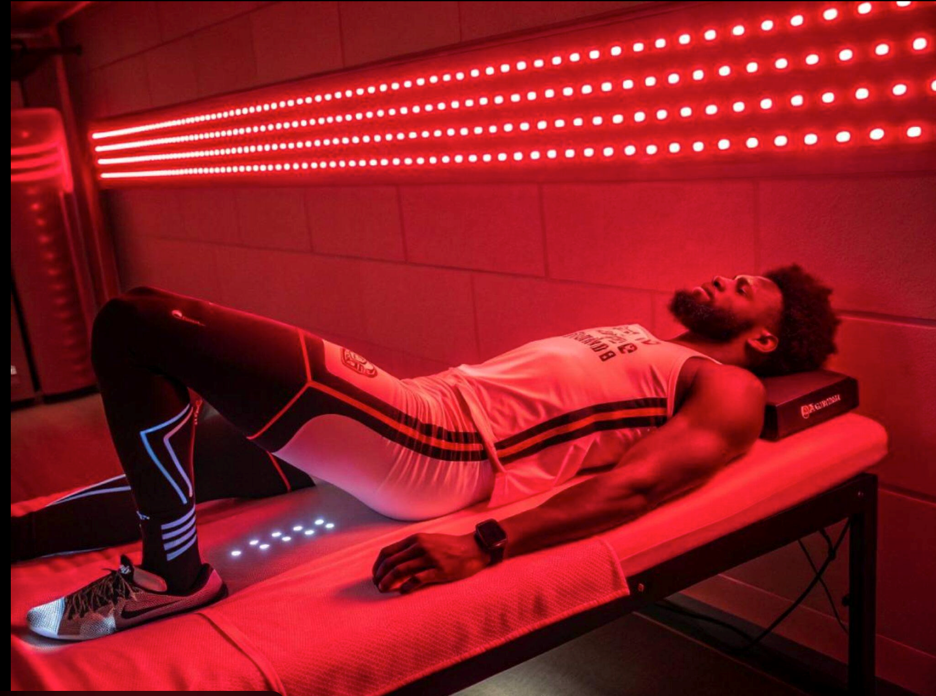 Person using a full-body red light therapy system